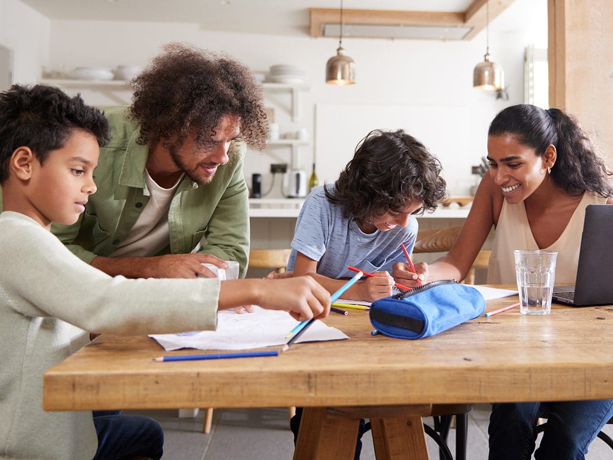 family working together at a table doing. homework