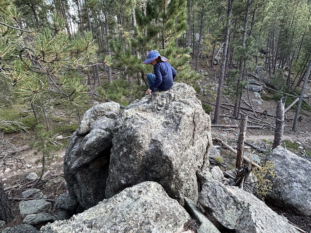 Child sitting on boulders in black hills wilderness