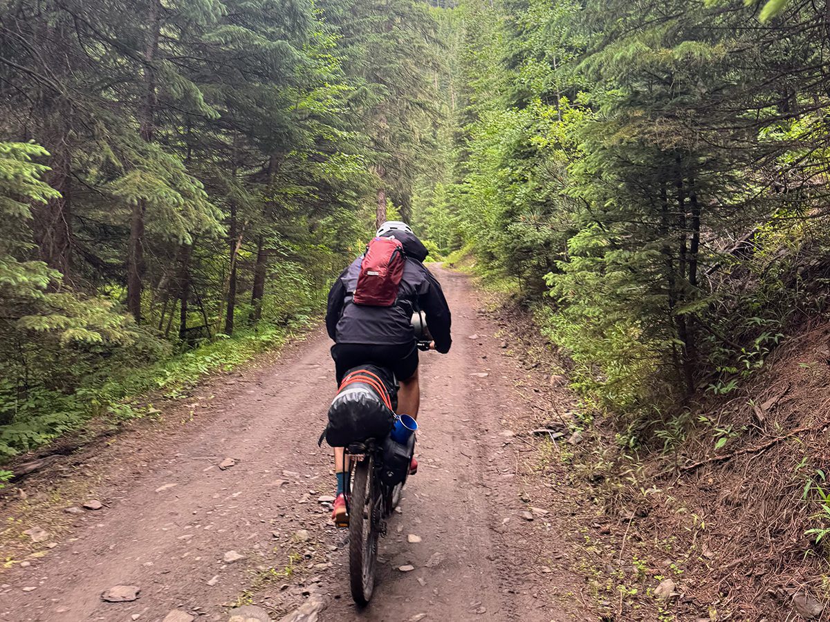 Man bikepacking on a dirt trail in the Black Hills
