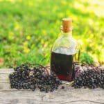 Elderberries with bottle of elderberry syrup