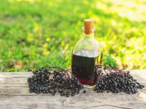 Elderberries with bottle of elderberry syrup