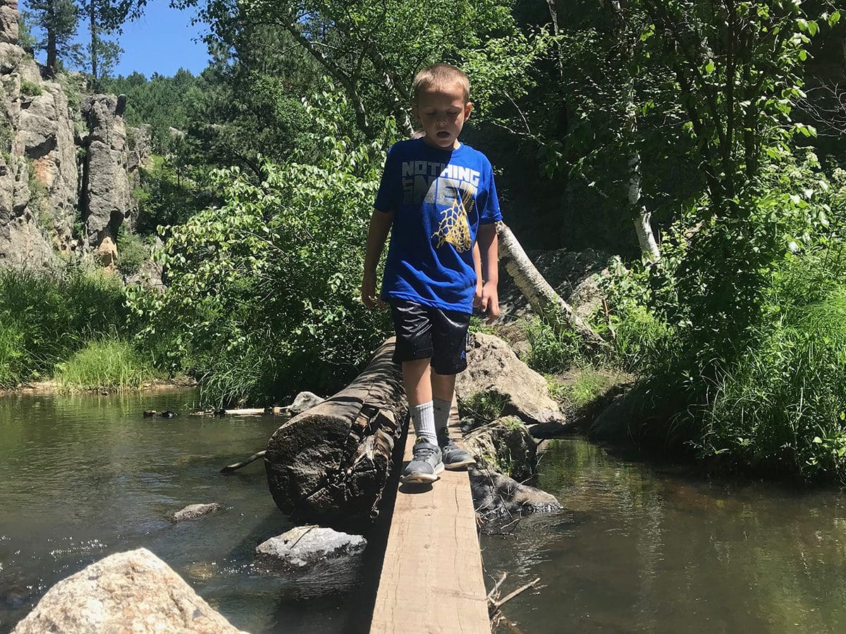 boy crossing water on Grace Coolidge Trail