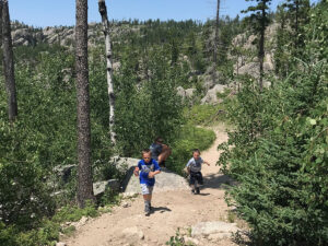 little devils tower trail boulder kids running on gravel trail 300x225
