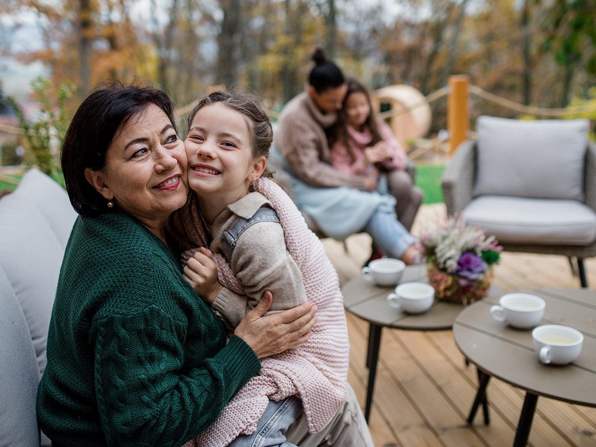 Two women and two girls enjoying a patio in backyard