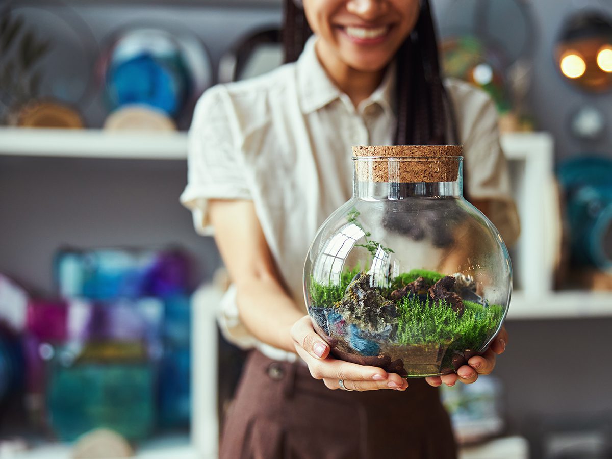 woman holding a glass terrarium