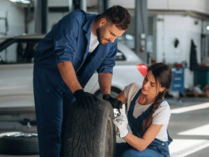 Car mechanics inspecting tire
