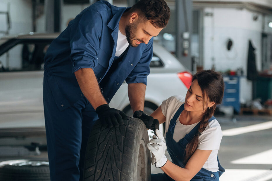 Car mechanics inspecting tire