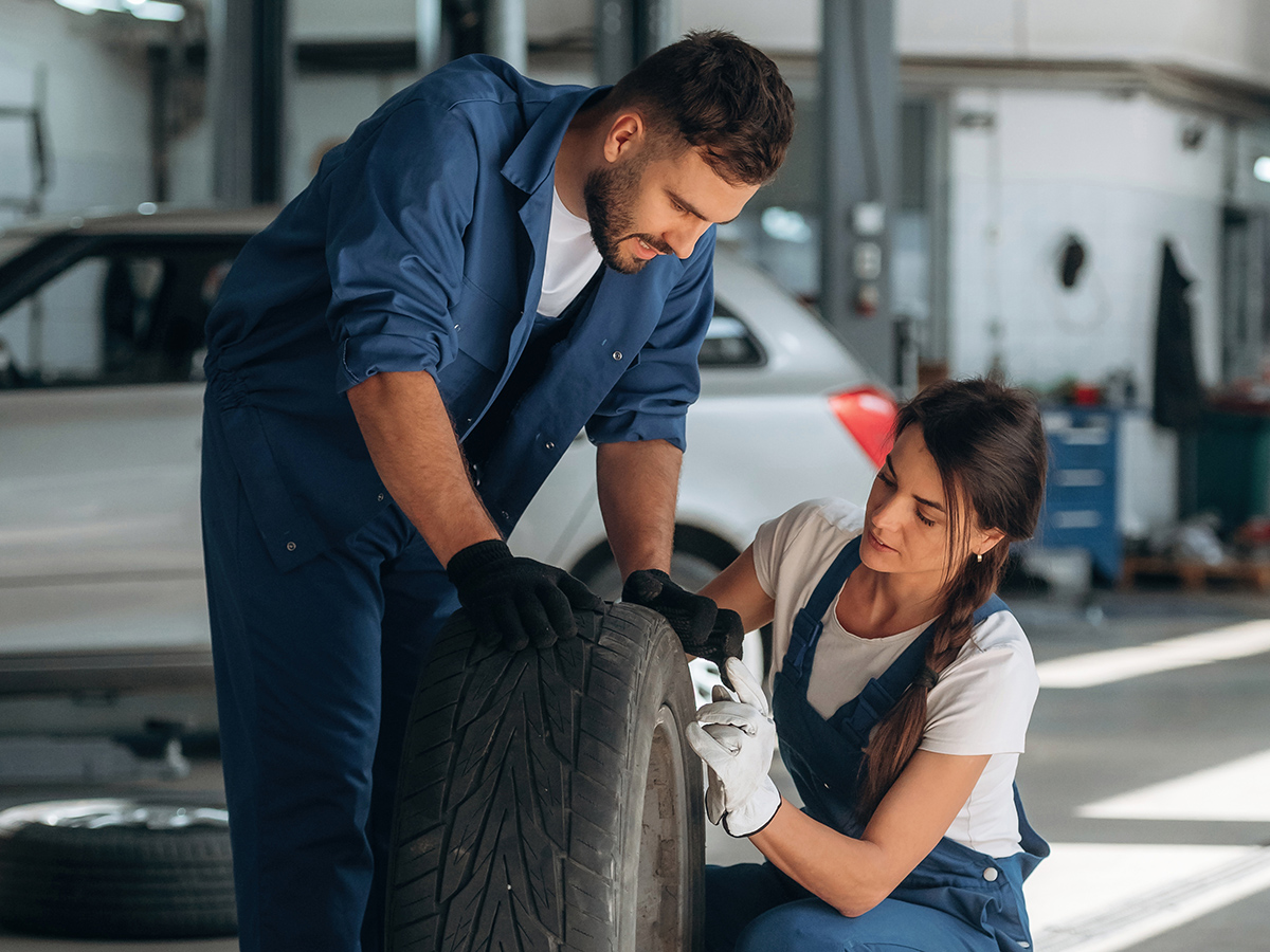 Car mechanics inspecting tire