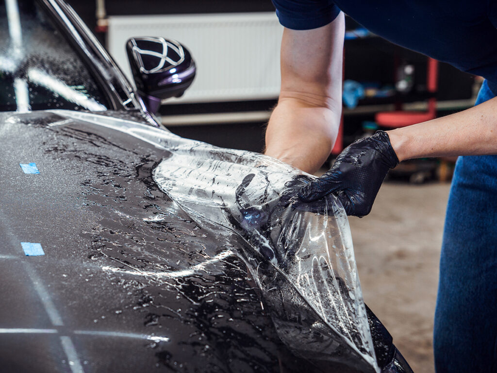 Paint protection film being installed on a car