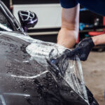 Paint protection film being installed on a car