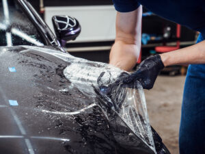 Paint protection film being installed on a car