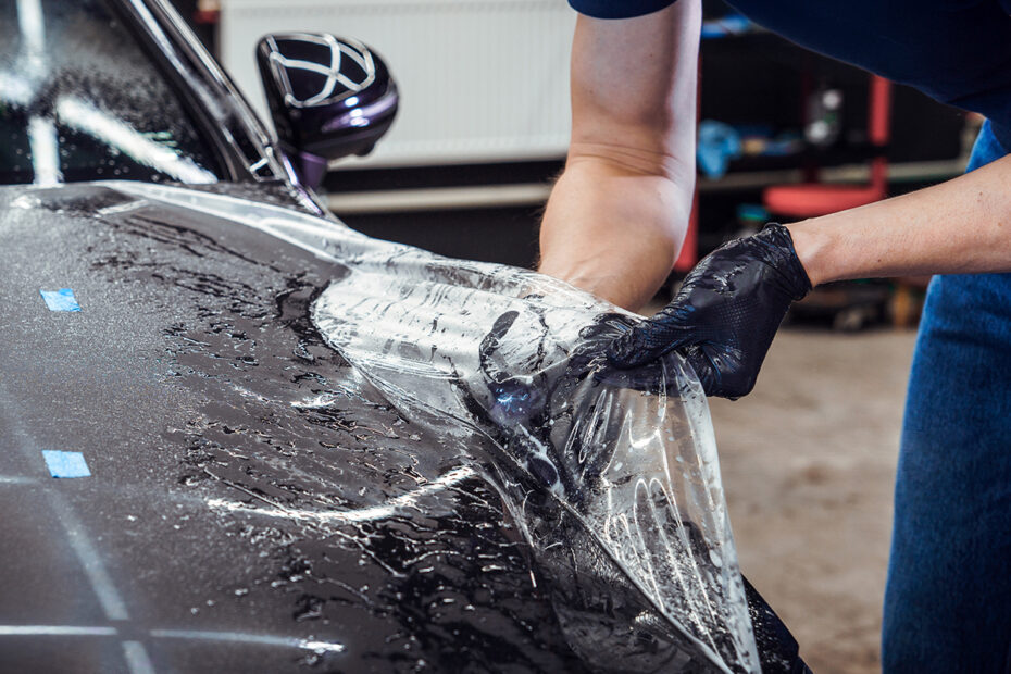 Paint protection film being installed on a car