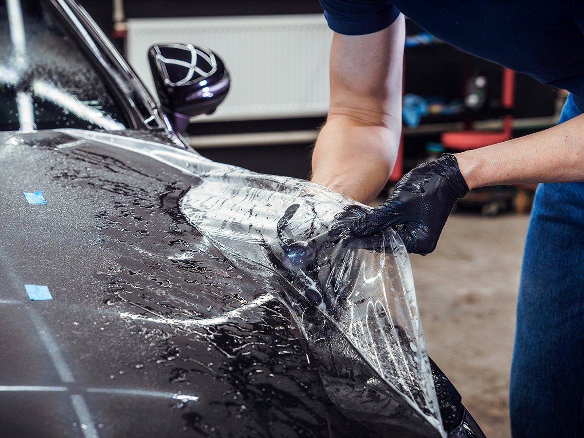 Paint protection film being installed on a car