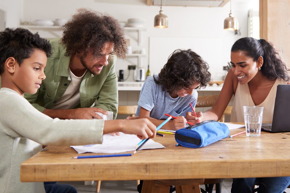 family working together at a table doing. homework